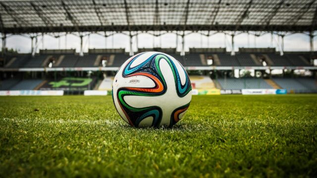 multicolored soccer ball on green field